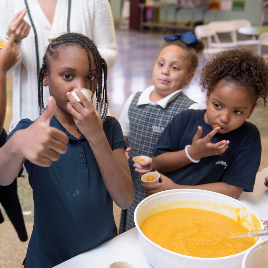 Children enjoying soup in cafeteria