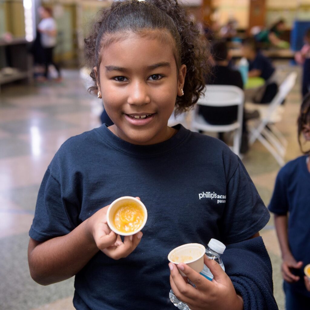 Child enjoying soup sample in cafeteria. Credit Ian Douglas